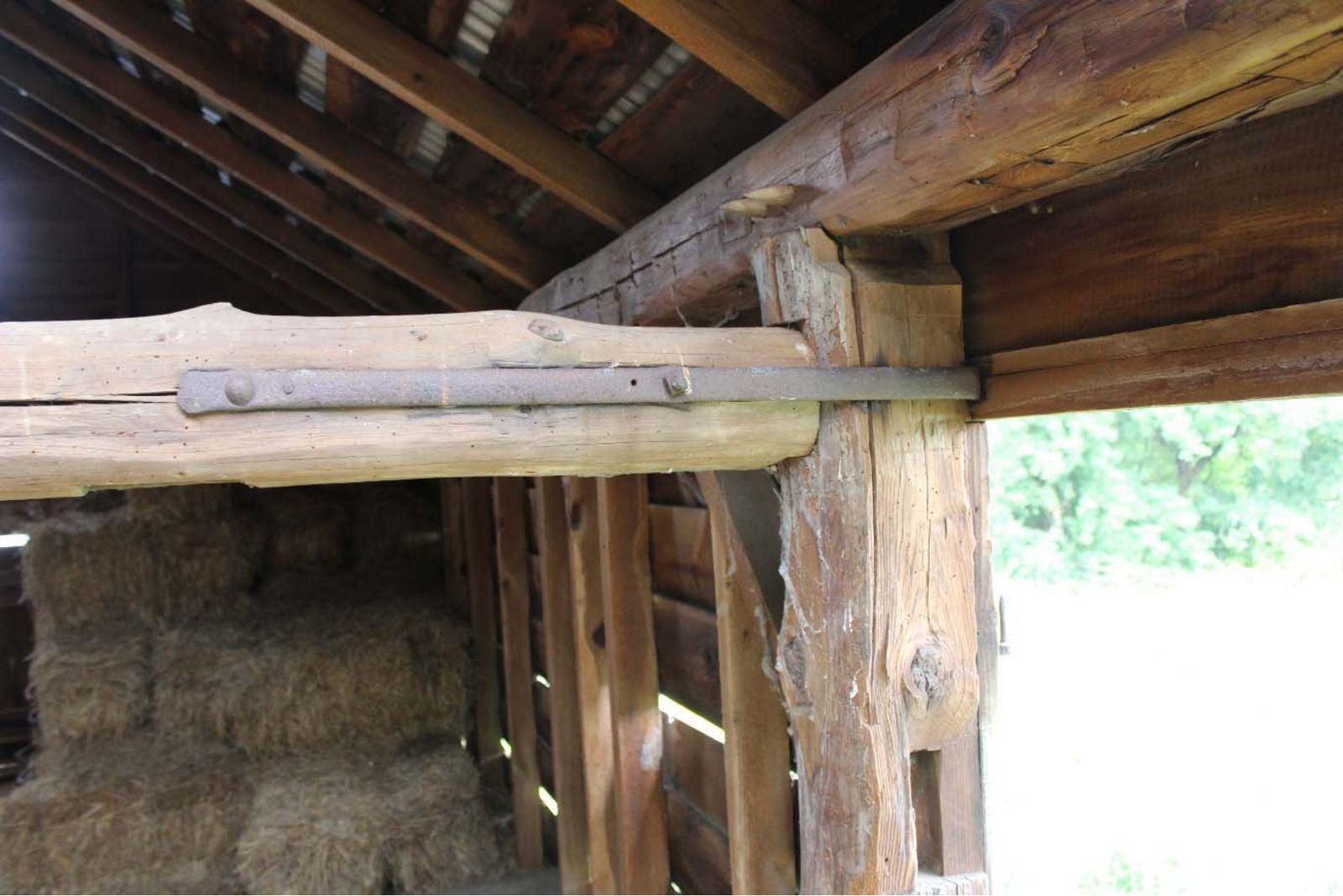 Wrought iron strap connecting a purlin to the wall post.