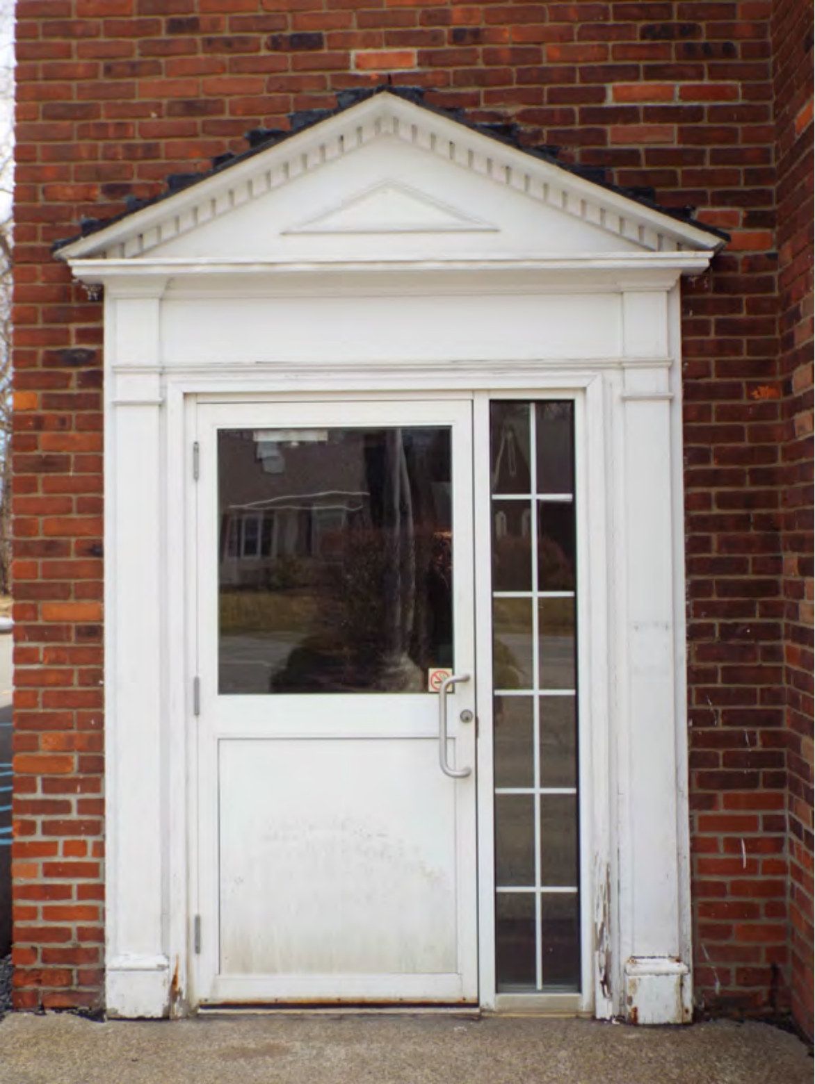 One of the main entrances with its classical door surround.