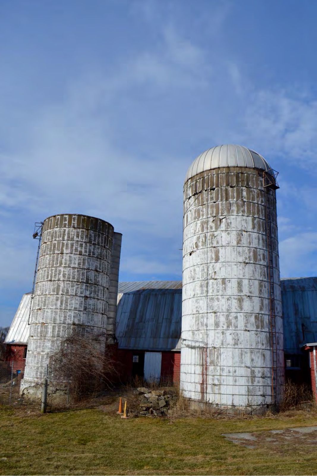The two concrete stave silos beside the main barn.